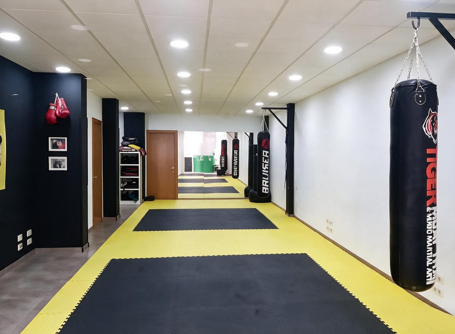 La sala de Be Water: tatami negro y amarillo con sacos de boxeo